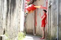 Happy Chinese woman in red cheongsam walk in the alley