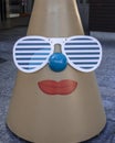 Happy christmas cone face wearing sunglasses in a city mall