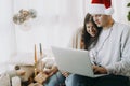 Happy christmas family shopping online or video call on laptop in room with xmas presents and decor Royalty Free Stock Photo
