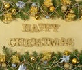 Happy Christmas golden text and spruce branch and Christmas decorations on a golden Royalty Free Stock Photo