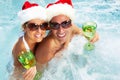 Happy Christmas santa couple in jacuzzi. Royalty Free Stock Photo