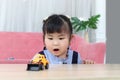 Happy chubby Asian girl with surprise expression face, portrait of surprised cute little toddler girl child looking at her toy in Royalty Free Stock Photo