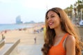 Happy city woman go to the beach at sunset. Smiling young woman going to Barceloneta famous Barcelona beach, Catalonia, Spain.