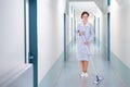 Happy cleaner mopping floor in hospital Royalty Free Stock Photo