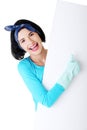 Happy cleaning woman showing blank sign board. Royalty Free Stock Photo