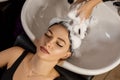 Happy client in a hair salon who wash her hair with shampoo Royalty Free Stock Photo