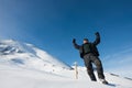 Happy climber with an ice ax in the snowy mountains