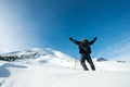 Happy climber with an ice ax in the snowy mountains.