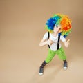 Happy clown boy with large colorful wig.