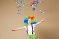 Happy clown boy with large colorful wig. Let`s party! Funny kid