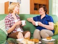 Happy colleagues drinking tea and talking during pause for lunch Royalty Free Stock Photo