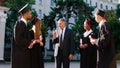 Happy college professor congratulated his students on their graduation day in the college garden all together are Royalty Free Stock Photo