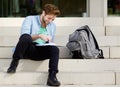 Happy college student sitting outside on campus Royalty Free Stock Photo