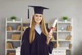 Portrait of happy college or university graduate holding diploma and smiling at camera Royalty Free Stock Photo