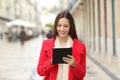 Happy coman checking tablet content in the street Royalty Free Stock Photo