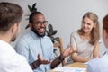 Happy confident african male business coach leading diverse team meeting