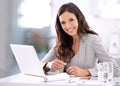 Happy, confident and ambitious business woman working on her laptop while sitting at her desk. Portrait of a beautiful Royalty Free Stock Photo