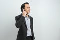 Happy confident asian indonesian business man in suit talking on phone on isolated background