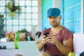 Happy and confident backpacker man working with laptop computer and mobile phone outdoors relaxed as successful freelance Royalty Free Stock Photo