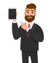 Happy confident business man showing a blank screen tablet computer and pointing towards it. Royalty Free Stock Photo