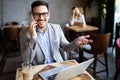 Happy confident businessman sitting with laptop at office Royalty Free Stock Photo