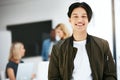 Happy, confident and carefree business man relaxing in a modern office with colleagues in the background. Portrait of a Royalty Free Stock Photo