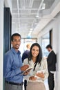 Happy diverse office workers standing in office hallway, vertical portrait. Royalty Free Stock Photo