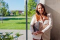 Happy confident office worker holding laptop by window. Caucasian young woman looking at camera. Business Royalty Free Stock Photo