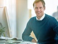 Happy, confident and smiling businessman sitting at his desk and feeling satisfied with his career and job choice Royalty Free Stock Photo