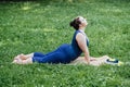 Happy confident smiling plus size curvy woman doing yoga stretching pilates workout, exercising outdoors.