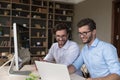 Happy confident twins in glasses working on family startup