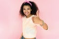 Happy african girl look at camera show thumbs up on pink studio background Royalty Free Stock Photo