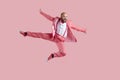 Happy funny young male dancer jumping high in the air isolated on a pink background Royalty Free Stock Photo