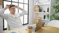 Happy and confident, young caucasian man working on his laptop in an indoor office workplace