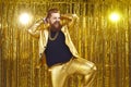 Happy confident bearded man in golden party suit dancing and having fun at disco club Royalty Free Stock Photo