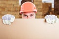 Happy constructor standing behind cardboard