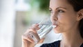 Happy consumer girl drinking clean pure water from transparent glass