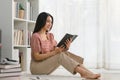 Happy contented young woman relaxing reading a book on the floor. Royalty Free Stock Photo