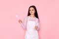 woman in chef apron holding spoon and spatula
