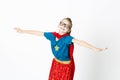 Happy and cool blond supergirl with glasses and red robe und blue shirt is posing in the studio Royalty Free Stock Photo