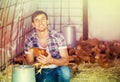 Happy countryman holding brown chicken