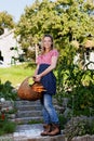 Happy countrywoman with a basket with carrotts
