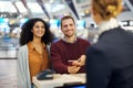 Happy couple, airport reception and passport document for woman at help desk, concierge or identity for travel. Man Royalty Free Stock Photo