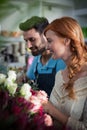 Happy couple arranging flowers