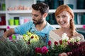 Happy couple arranging flowers