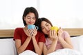 Happy Couple  asia woman enjoy together with drink morning coffee, fresh tea or hot milk in cup on the bed in morning Royalty Free Stock Photo