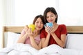 Happy Couple  asia woman enjoy together with drink morning coffee, fresh tea or hot milk in cup on the bed in morning Royalty Free Stock Photo