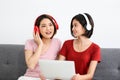 Happy Couple  asia woman wear headphones and enjoy musics playing mobile phone and tablet in bedroom Royalty Free Stock Photo