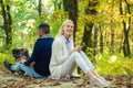 Happy couple on autumn walk. Business couple - man browsing Internet on a notebook, woman using mobile phone outdoors Royalty Free Stock Photo
