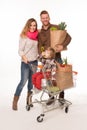 Happy couple and baby in shopping cart Royalty Free Stock Photo